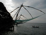 Chinese fishing nets.  Called "chinese" because  some chinese traders from the court of Kublai Khan supposedly introduced them.  The counterweighted nets are lowered into the water, a light suspended above them (these days electric), and prawns are collected.