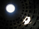 The Pantheon's only light comes from a hole in the top of the dome, called the oculus.  The dome's builders carefully selected and graded the aggregate material used in the dome's concrete.  It ranges from heavy basalt in the foundations of the building and the lower part of the walls to the lightest of pumice toward the center. In addition, the uppermost third of the cylinder of the walls, seen from the outside, coincides with the lower part of the dome, seen from the inside, and helps contain the thrust with internal brick arches. The cylinder has walls that are 20 feet thick.