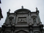 The top of the facade of San Rocco.  Saint Rocco spent his life caring for plague sufferers.  (If the picture were better, you could see bodies being carried off in the relief.)  When he returned home, he was so thin and looked so terrible that nobody recognized him. Instead they tossed him in the slammer.  Only his faithful dog kept him company.  That's why he is often represented with a small dog.  In 1485, his body was moved to Venice, and he became one of the protectors of the city.  (No word on whether he likes that job or not.)