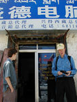 In front of an internet place.  Notice the sign is written mainly in Chinese with Tibetan in the small letters on top.  In the Chinese part of town, there is often no Tibetan at all.
