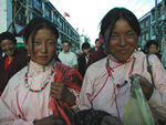 Two girls.  The girl on the right has a clother covering for her sleeve.  This is a common protection for sleeves among the butchers and street workers.