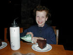 Happy girl with chocolate cake and an unusual present wrapped in a handkerchief