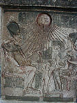 Characteristic relief showing the sun disk bestowing blessings on people.  The Aton was never shown in human or animal form, except insofar as the extended rays of the sun disk might end in hands to confer blessings upon men. This was the life-giving and life-sustaining power of the sun. He had no image in the hidden sanctuary of a temple but was to be worshiped out in sun-warmed openness. The buildings for the Aton were of a new kind. The massive solidity of the older temples was given up, and walls were run up of much smaller stones and were jammed with excited little scenes in a feverish new art. There is one of these reliefs in Luxor, and compared to the sedate reliefs of earlier and later periods, looks like the work of drugged kindergarteners.  