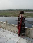 Maggie on the mausoleum's platform admiring the Yamuna River.  Some say Shah Jahan intended to build his own mausoleum on the far bank of the river and link it to the Taj with a bridge.  Jahan was deposed by his son and imprisoned in the Agra Fort .  Ultimately, his son interred him in the Taj alongside his beloved wife.
