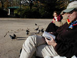 Mark "conversing" with two people in the park.  Note dictionary.  He's looking up how to say pigeon.